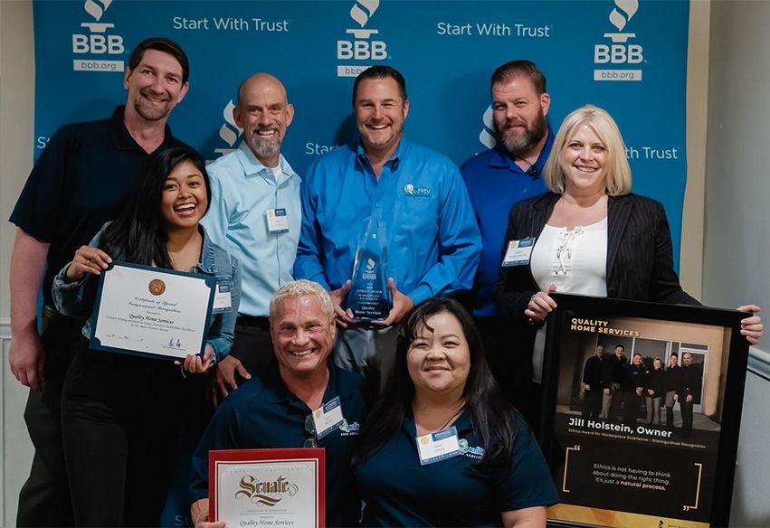 Quality Home Services staff with BBB award