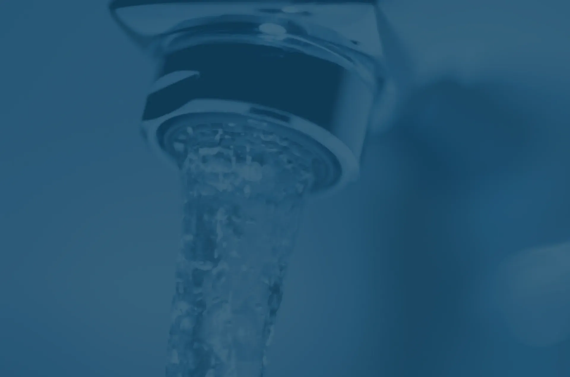 A close-up of a faucet with water flowing steadily, captured in a soft blue tone, conveying a calming and refreshing atmosphere.
